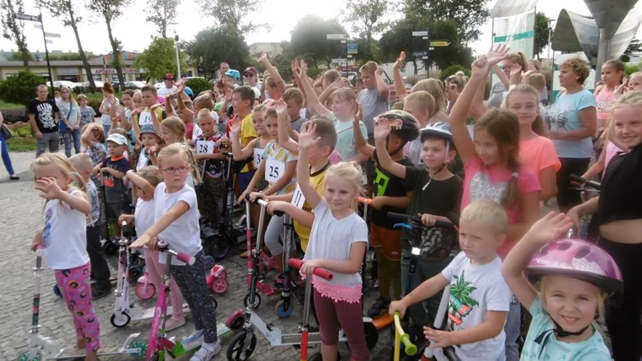 Mali miłośnicy jazdy na hulajnogach na skwerze przy fontannie