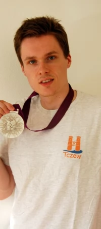 Bartek Piasecki z olimpijskim medalem w koszulce z logo miasta