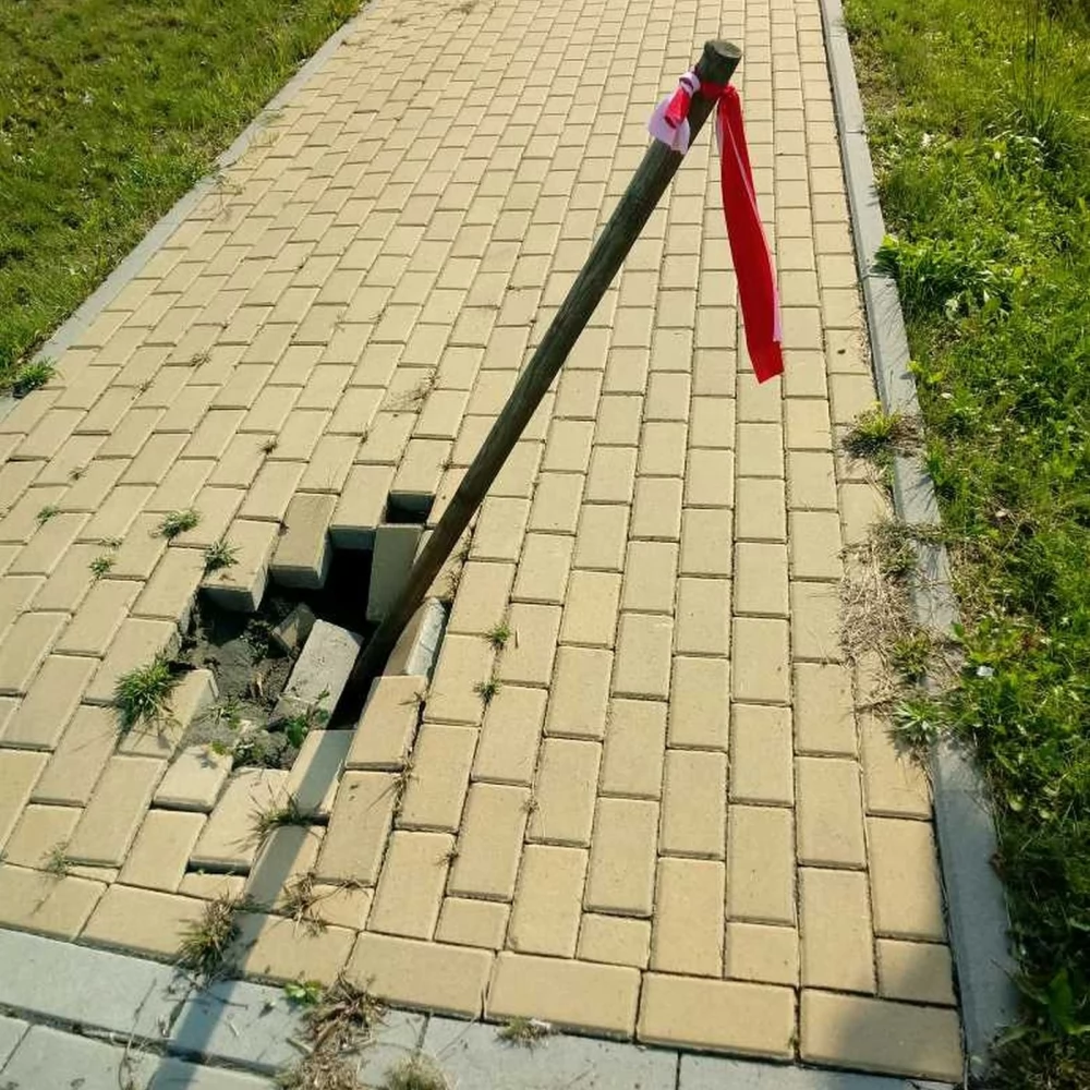 Zapadnięty chodnik obok sklepu ogrodniczego na 30 Stycznia